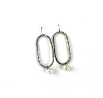 Perla blanca con pendientes oblongos de plata martillados.
