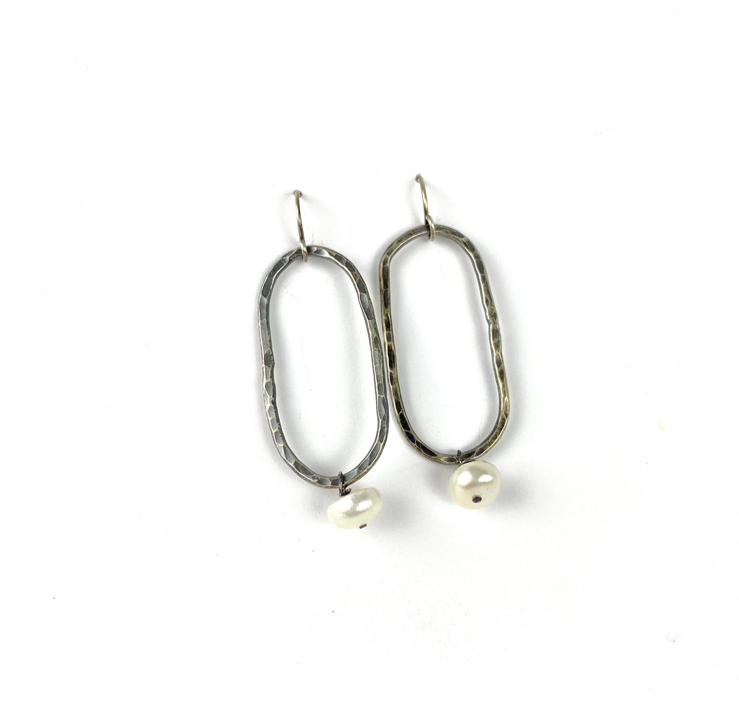 Perla blanca con pendientes oblongos de plata martillados.